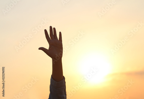 Silhouette of hand with sky sunset background.