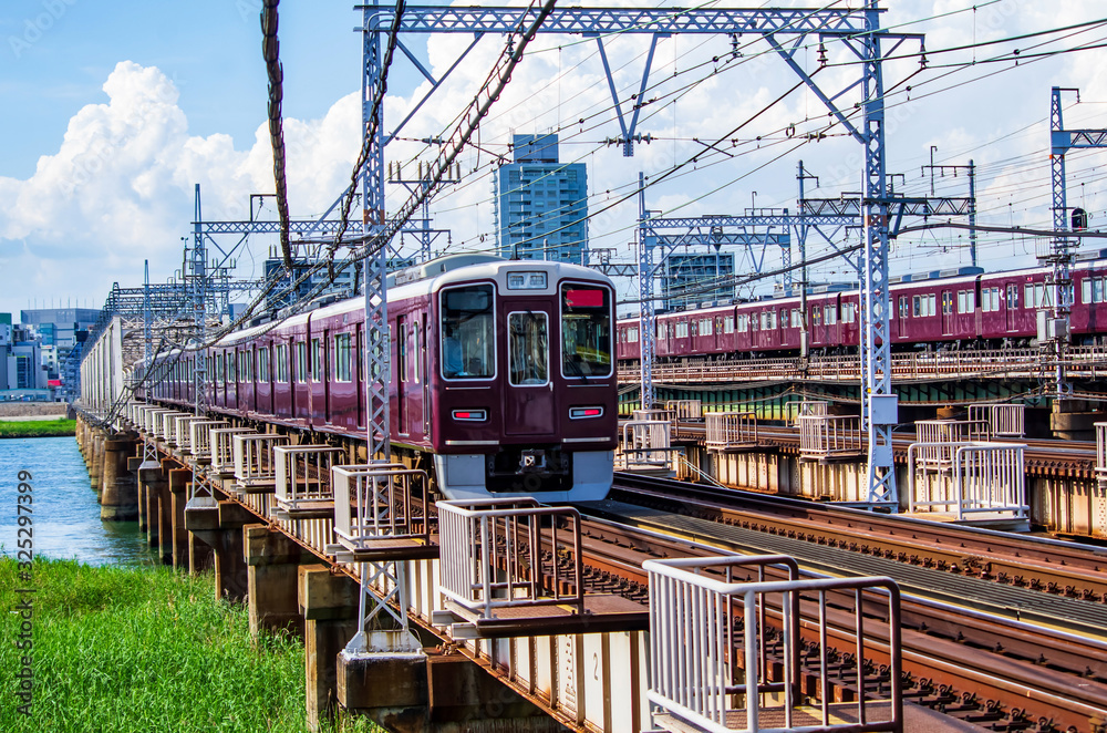 Fototapeta premium Pociąg przejeżdżający przez żelazny most na rzece Yodogawa w Osace