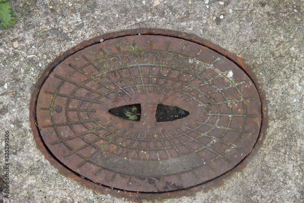 cast iron lid of a well where the fire hydrant is hidden and can be used in the event of a fire