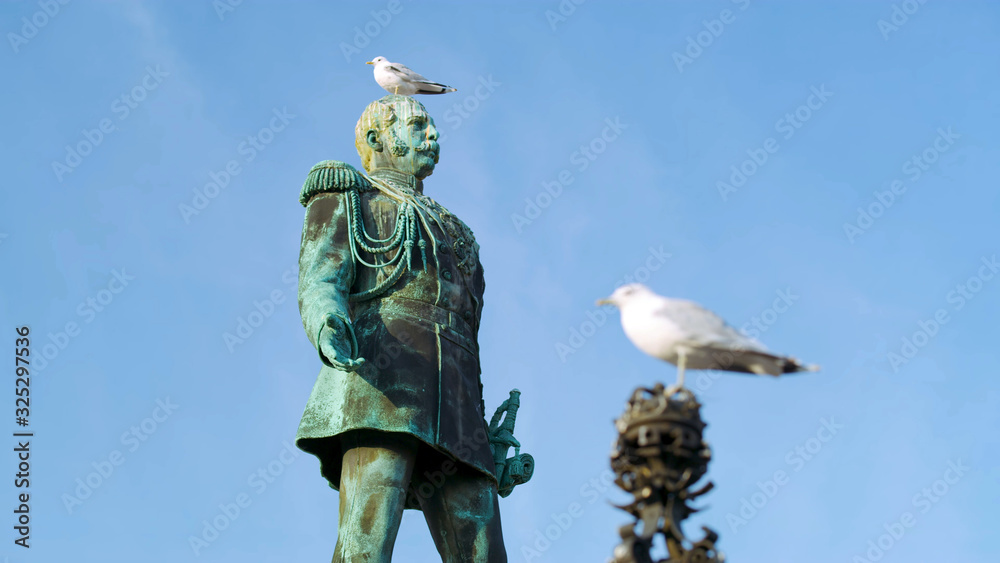 Obraz premium Metal statue of a military commander, green, in Helsinki, close-up with a seagull on his head