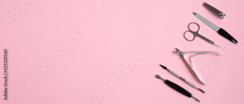 Manicure and pedicure tools on pink background. Top view with copy space. Nail salon banner design template. Beauty treatment and hand care concept