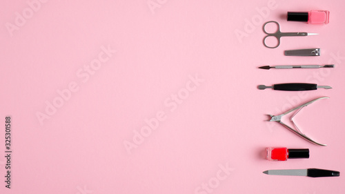 Manicure and pedicure tools on pink background. Top view with copy space. Nail salon banner design template. Beauty treatment concept