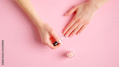Woman giving herself elegant manicure applying polish on nails at home. Beauty treatment and hand care