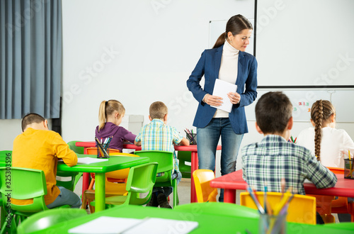 Little children working with teacher in classroom