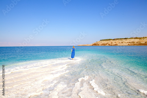 Woman stands on the Death Sea beach in Jordan