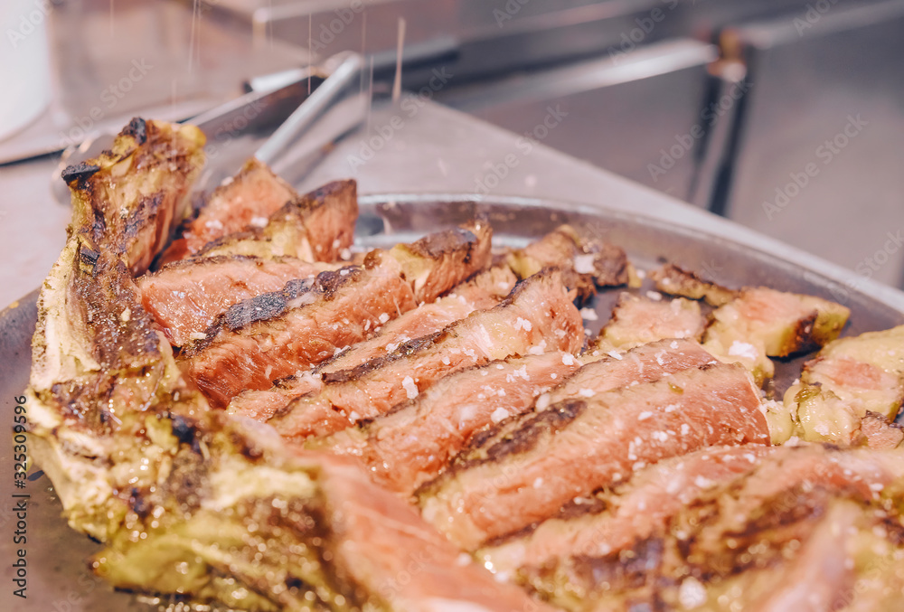 Grilled T-bone steak on a restaurant kitchen plate