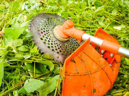 Mowing grass with an old gas mower. Seasonal garden cleaning with a lawn mower concept