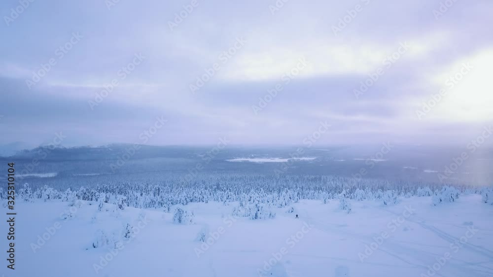 View from above with skier skiing down from the hill in northern Finland, Lapland View from above with skier skiing down from the hill in northern Finland, Lapland