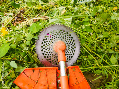 Mowing grass with an old gas mower. Seasonal garden cleaning with a lawn mower concept