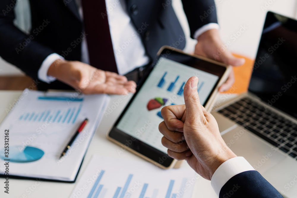 Businessman show thumb up for the best market chart graph as meeting Businessman show thumb up for the best market chart graph as meeting