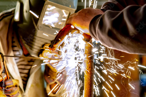 Welding a rusty pipe in a garage. Industrial series.