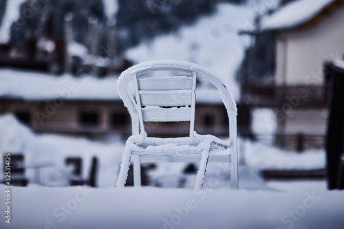 кресло в снегу по центру карта на улице зимой с размытым фоном в синих оттенках