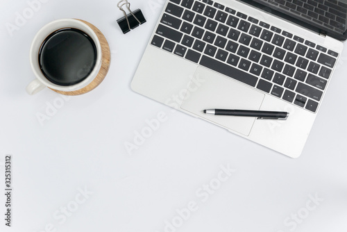 Flat lay,Office desk working space with laptop,smartphone,notepad,coffee cup,green leaf and notebook.Top view with copy space for text or image.background working desk concept.