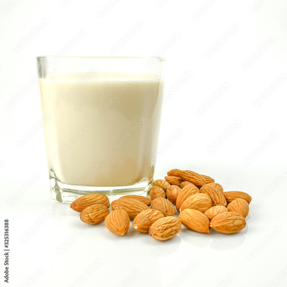almond kernel and almond milk in the glass isolated on white background almond kernel and almond milk in the glass isolated on white background