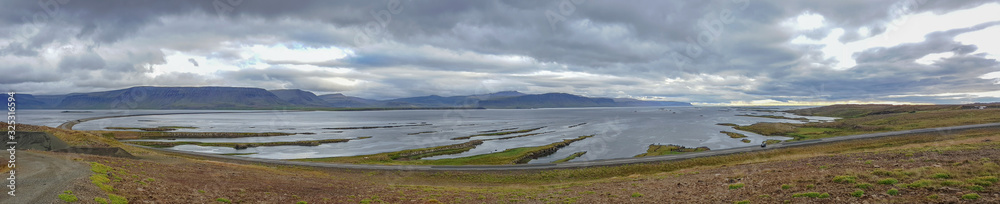 Panorama einer Fjordlandschaft in Islands Norden unter dramatischem Himmel