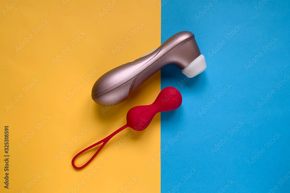 Sex toys. Geisha ball and vibrator on a blue-yellow background. Useful for sex shop, adult