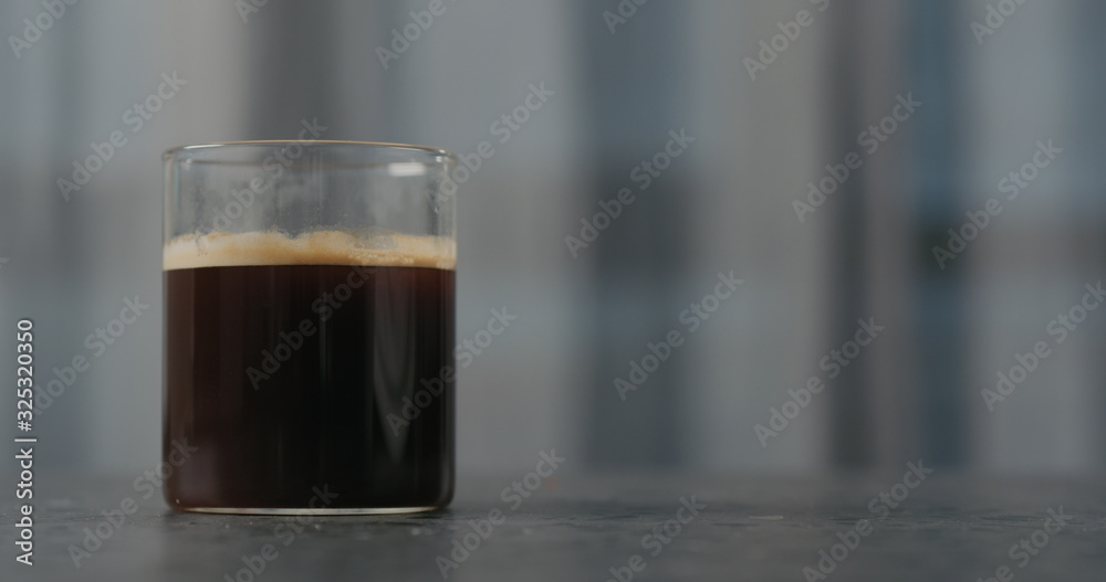 black coffee in glass on concrete countertop black coffee in glass on concrete countertop