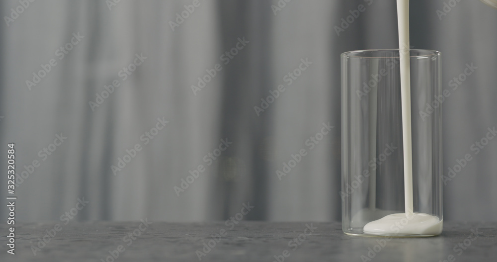pour white yogurt into glass on concrete countertop pour white yogurt into glass on concrete countertop