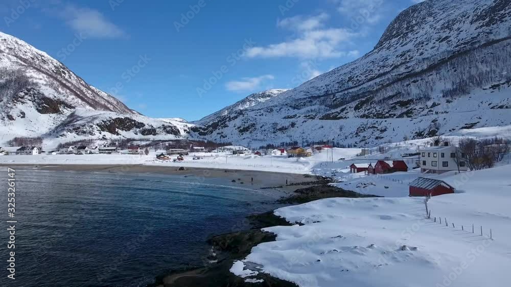Aerial view of Tromvik sea coast with few houses in small village during winter time in northern Europe, Norway