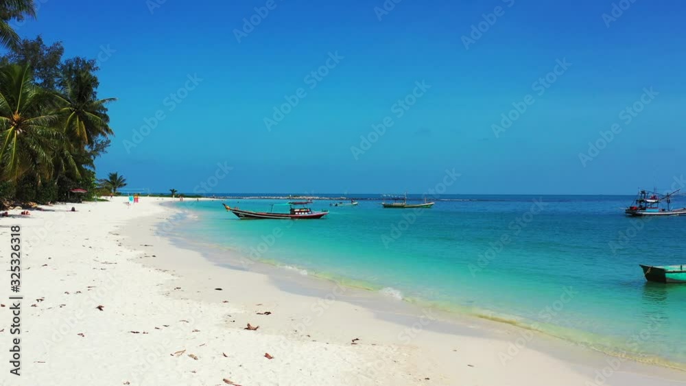 Beach landscape, palms white sand and turquoise water with floating boats Beach landscape, palms white sand and turquoise water with floating boats