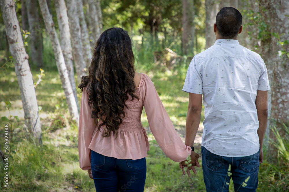 Romantic married Asian couple walking together in a park Romantic married Asian couple walking together in a park