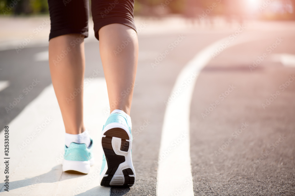 Closeup woman walking towards on the road side. Step, walk and outdoor exercise activities concept.