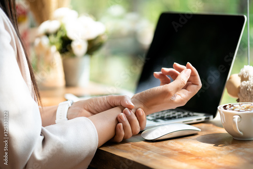 Tablou pe pânză Closeup woman holding her wrist pain from using computer