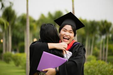 Graduation ceremony. Young female graduate hugging each other with her friend congratulate the student at the university.