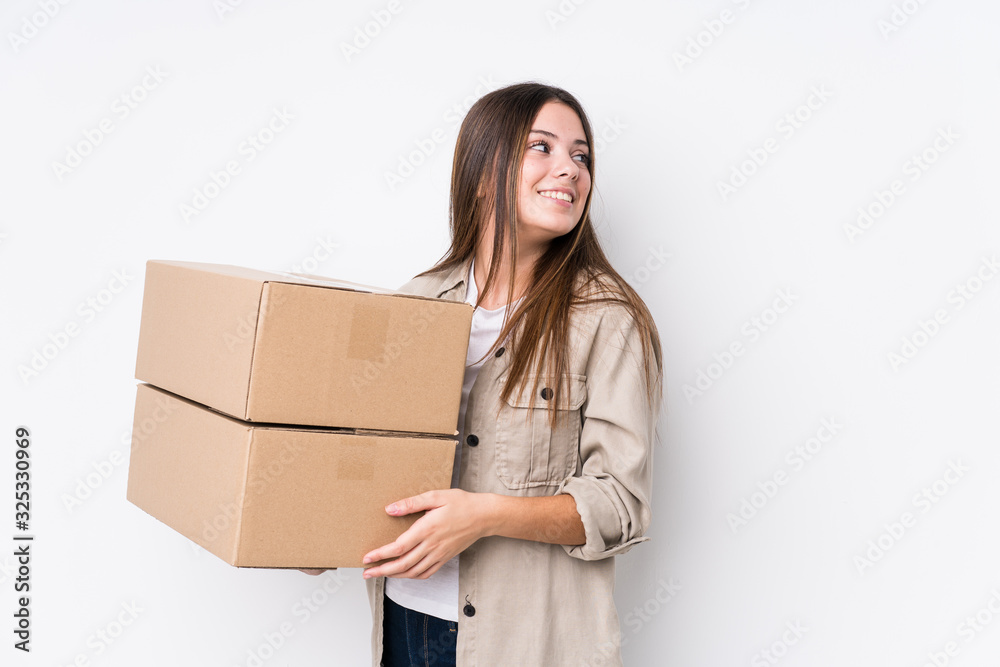 Young caucasian woman moving to a new home looks aside smiling, cheerful and pleasant. Young caucasian woman moving to a new home looks aside smiling, cheerful and pleasant.