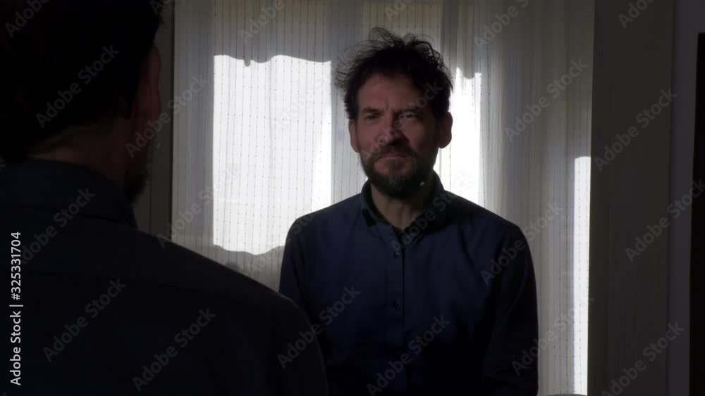 Sad man looking in mirror feeling depressed