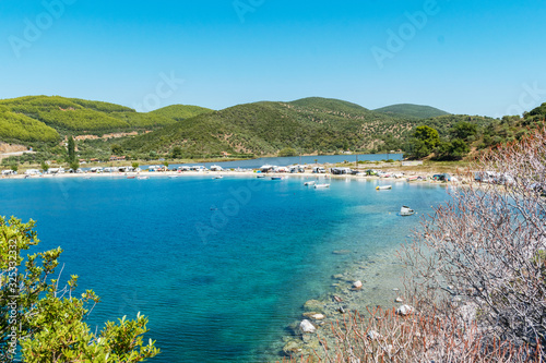 Porto Koufo  Greece  05 07 2019  View on famous Greek bay with many recreational vehicles parked around the beach and turquoise blue water. Perfect vacation place for camping lifestyle.