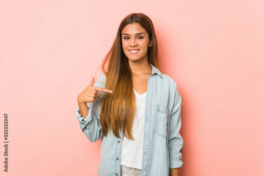 Young slim woman person pointing by hand to a shirt copy space, proud and confident Young slim woman person pointing by hand to a shirt copy space, proud and confident