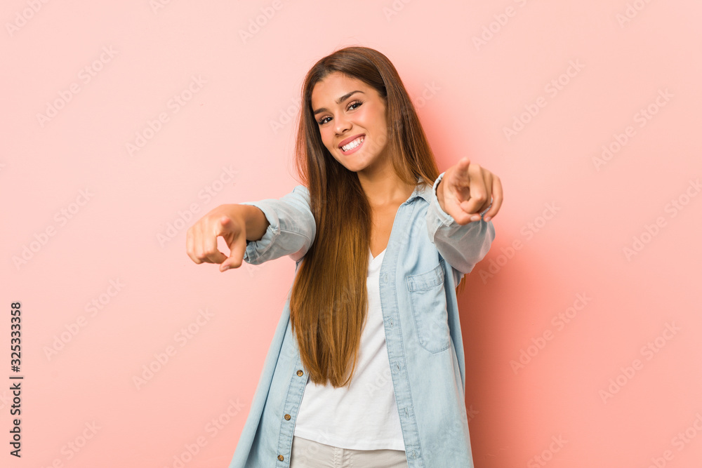 Young slim woman cheerful smiles pointing to front. Young slim woman cheerful smiles pointing to front.