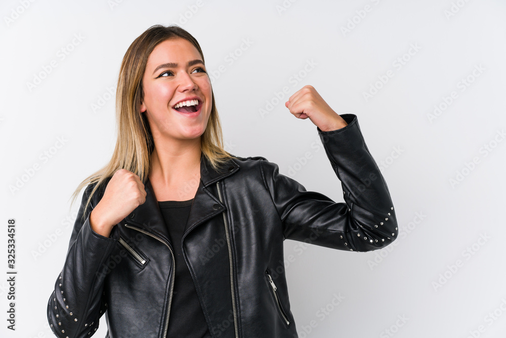 Young caucasian woman wearing a black leather jacket raising fist after a victory, winner concept. Young caucasian woman wearing a black leather jacket raising fist after a victory, winner concept.