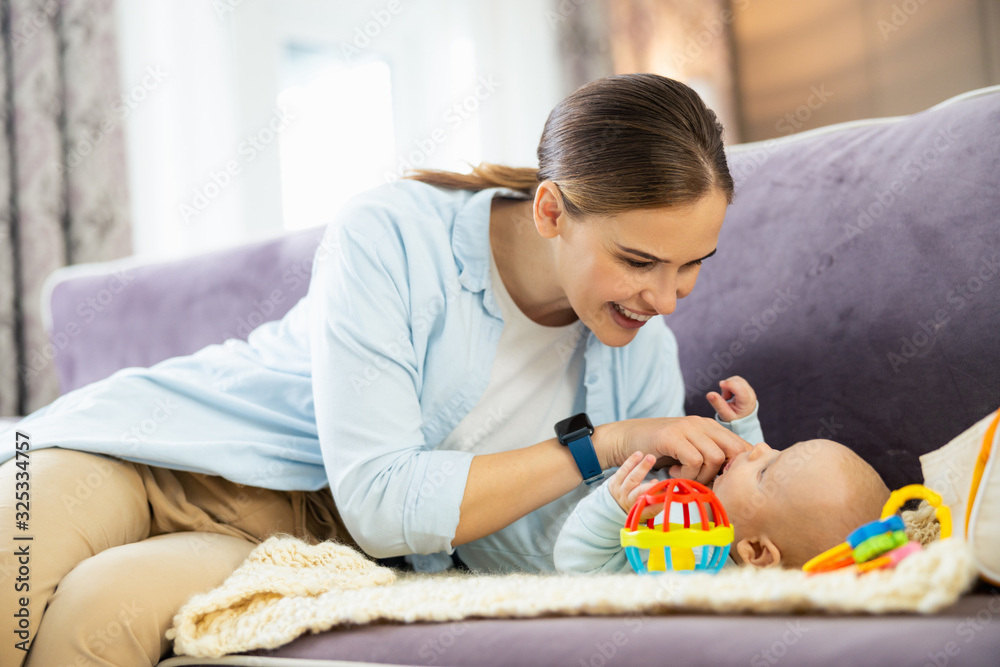 Happy young mother and child boy playing together indoors at home Happy young mother and child boy playing together indoors at home
