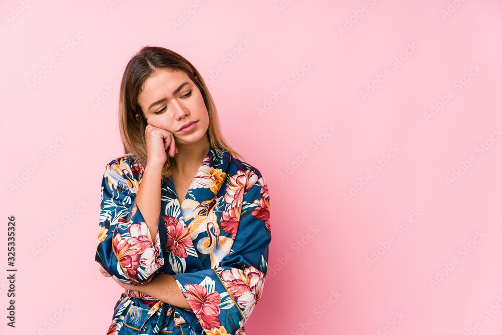 Young caucasian woman wearing pajamas who feels sad and pensive, looking at copy space. Young caucasian woman wearing pajamas who feels sad and pensive, looking at copy space.