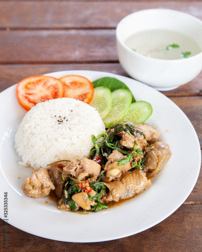 Rice topped with stir fried chicken and basil