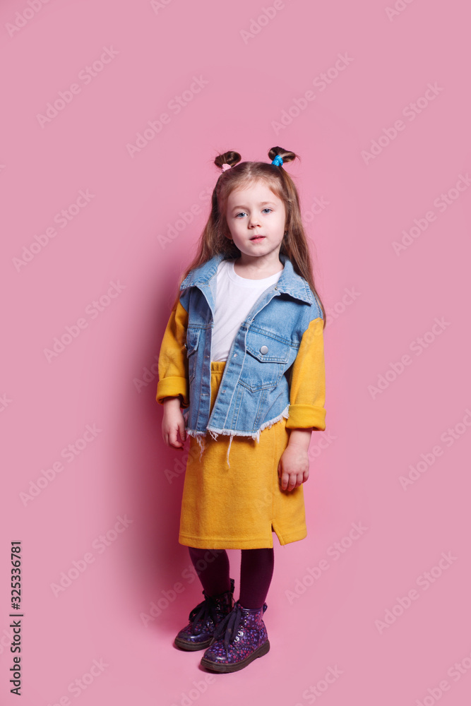 Little girl model in fashionable clothes on pink background Little girl model in fashionable clothes on pink background
