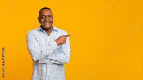 African american mature man pointing aside at empty space photo