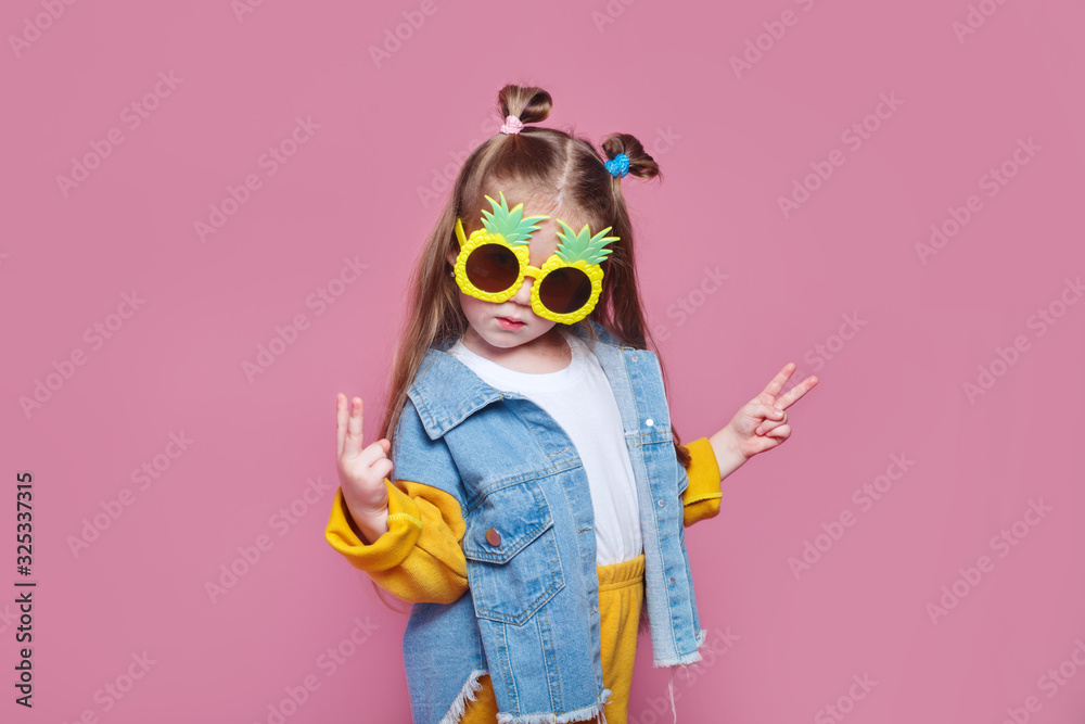 Summer fashion concept. cheerful little girl in big pineapple sunglasses on pink background - obrazy, fototapety, plakaty 