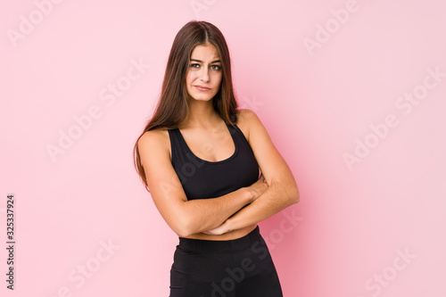Young caucasian fitness woman doing sport isolated unhappy looking in camera with sarcastic expression.