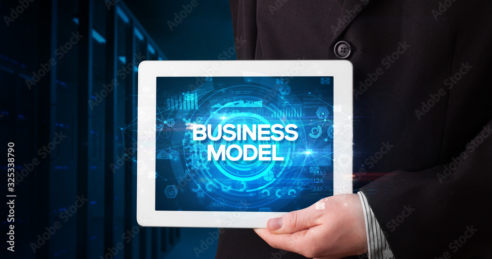 Young business person working on tablet and shows the inscription: BUSINESS MODEL, business concept