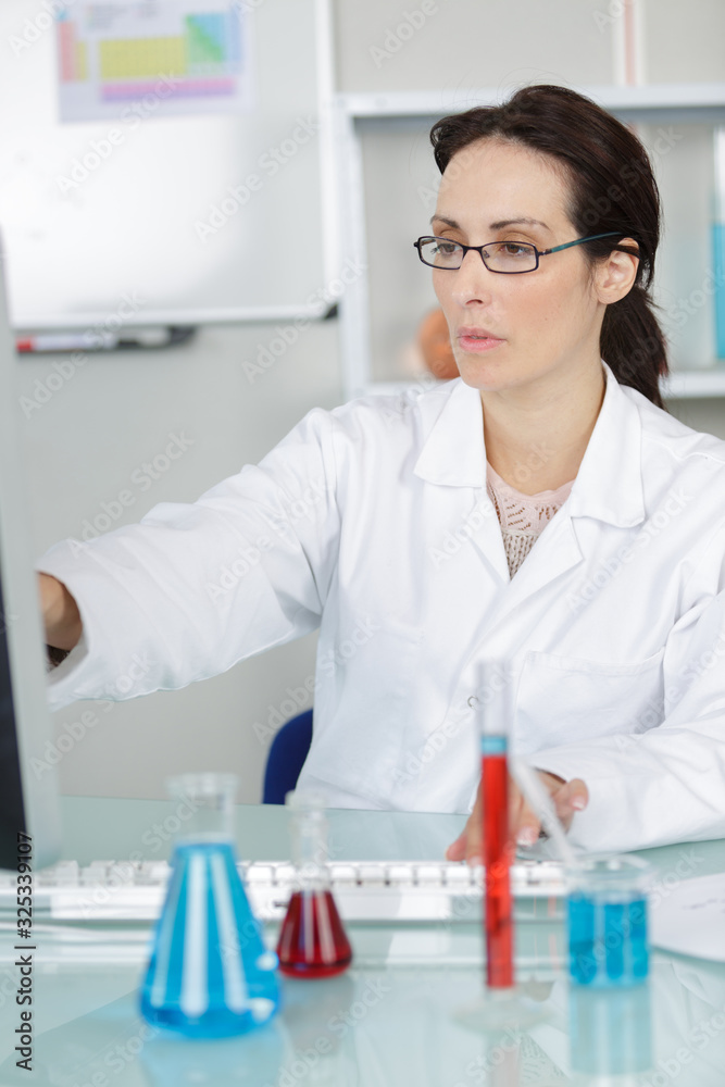 woman scientist studying chemical liquid in lab flask