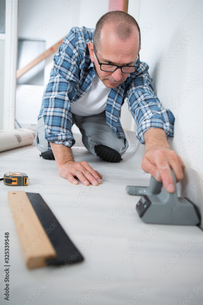 linoleum installer flattening the material on the floor linoleum installer flattening the material on the floor