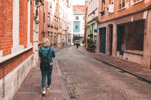 A woman walks along an empty street in Bruges, Belgium. © LALSSTOCK