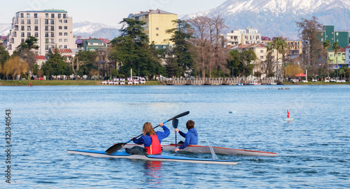 Two young male kayakers rowing on lake