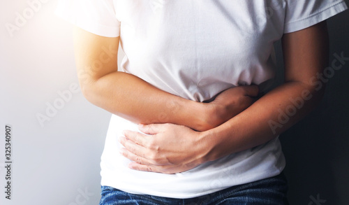 Asian women suffering with severe stomach pain, Stomach ache or menstrual pain.