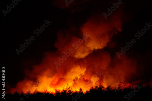 Big smoke from the burning sugarcane fields at night cause of pollution and environment impact.