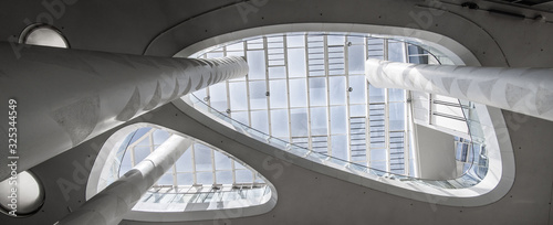 Super wide angle of a white atrium with skylight taken from below with columns that extend upwards photo