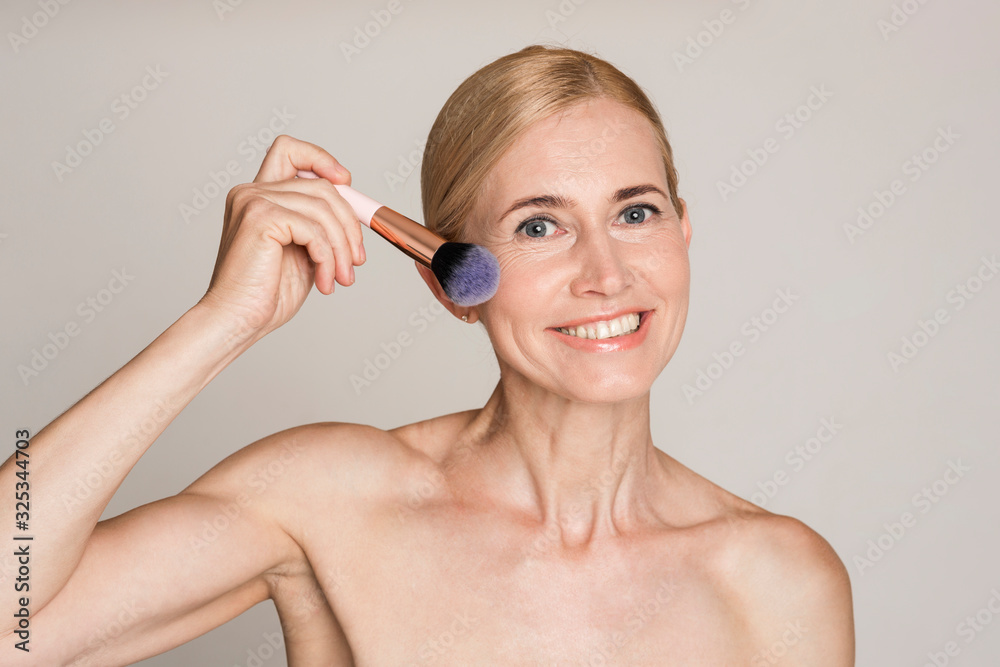 Beautiful caucasian middle aged woman using brush